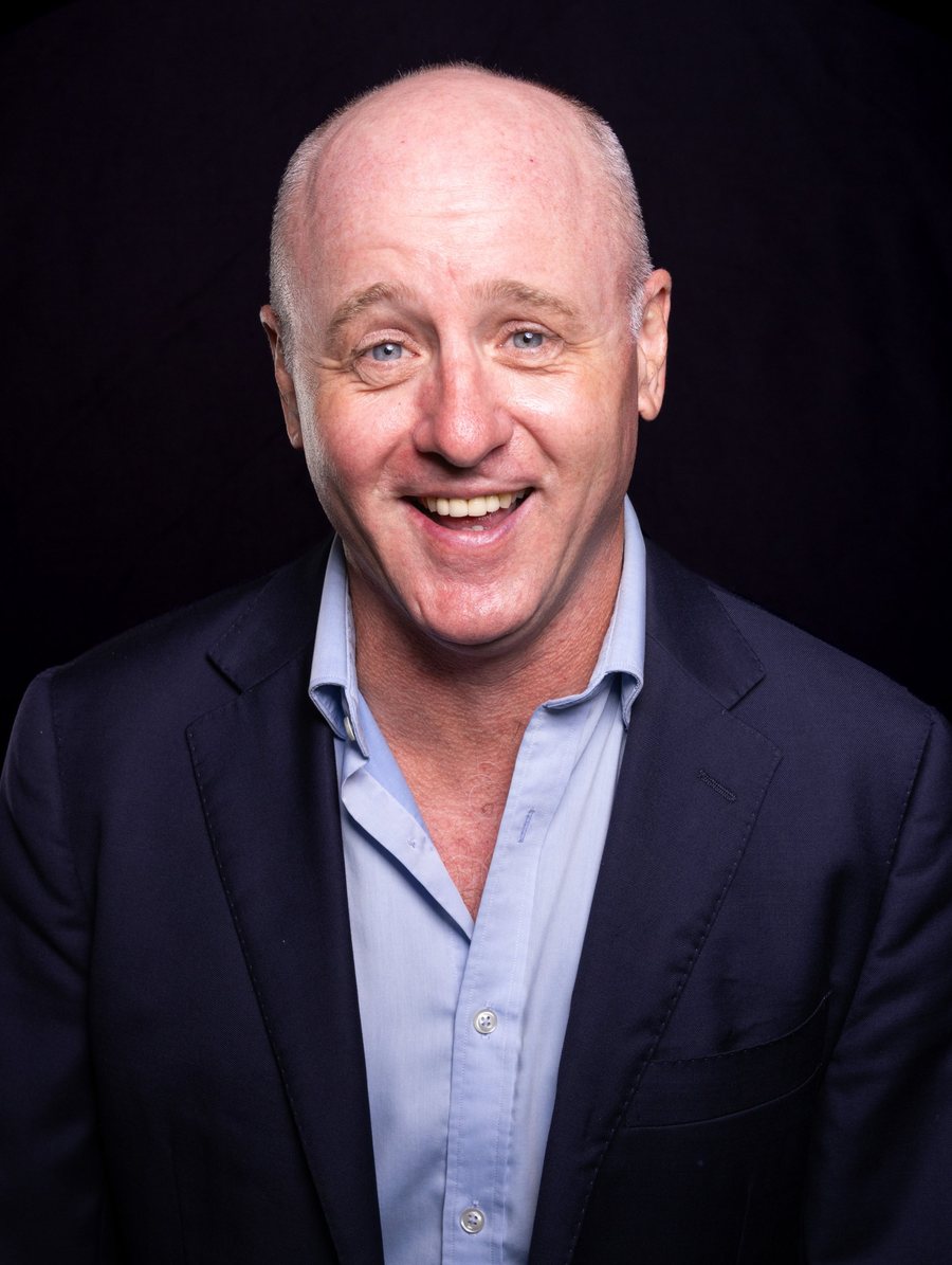 Dave Eastgate laughing, in a navy suit jacket